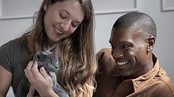 woman and man happily holding a Russian Blue kitten